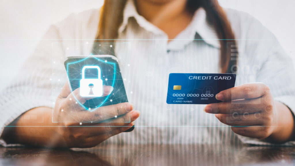 Woman holding smartphone and credit card with padlock icon on digital display cyber security internet and networking, Concepts online shopping for protection.